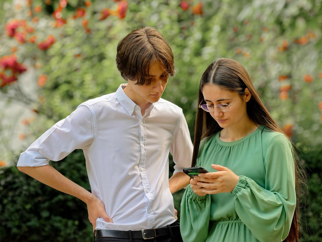 Two young people looking at phone together