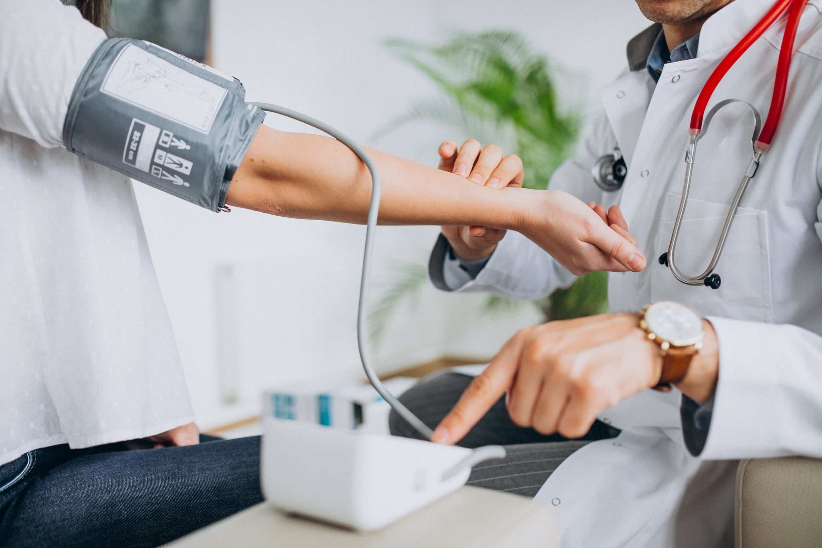 ohexam Close up of an arm with blood pressure cuff around it, being looked at by a person wearing a white coat with stethoscope around their neck